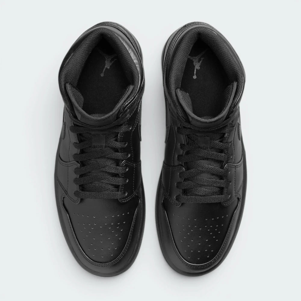 Focuses on the locked-in traditional lacing layout, displaying the perfect symmetry of the matte black cotton laces, the tonal textile tongue, and the iconic starburst perforation pattern tracking down the front leather toe box area.