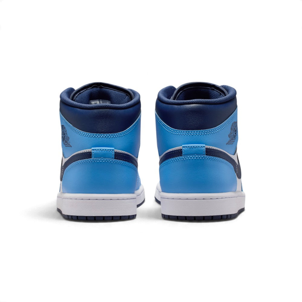Rear view of the sneakers emphasizing the heel overlays, stitched pull tabs, and the textured rubber sole wrap.