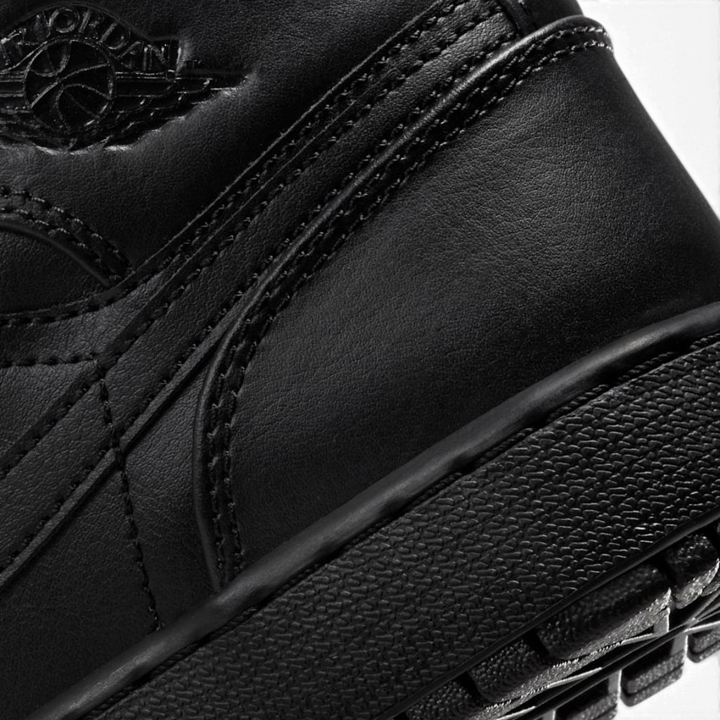Close-up of the lateral collar panel, highlighting the embossed Air Jordan Wings logo, premium leather grain, and reinforced stitching.