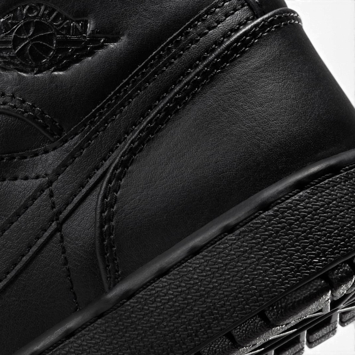Close-up of the lateral collar panel, highlighting the embossed Air Jordan Wings logo, premium leather grain, and reinforced stitching.