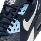 Close-up of a Nike sneaker in navy blue, black, and light blue, showing the side profile with the white Swoosh logo and textured panels.