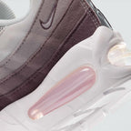 Highlights the "unreal" clean finish where the thick foam cushioning wall bonds securely to the high-friction road rubber outsole base, framing the prominent visible Air pods.
