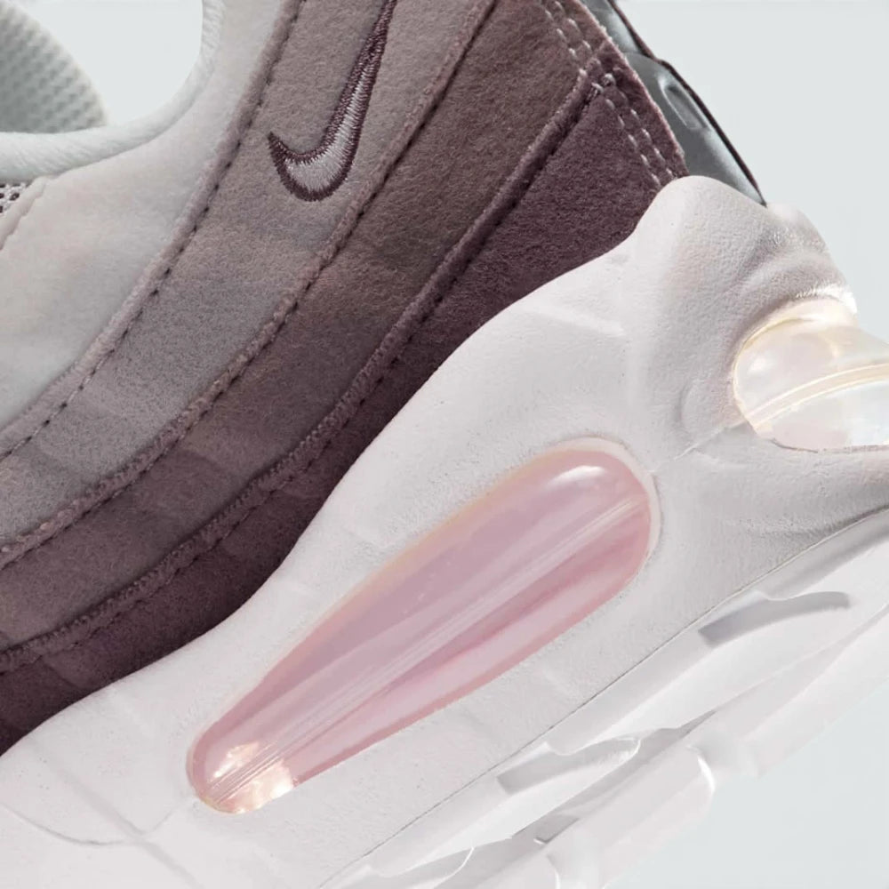 Highlights the "unreal" clean finish where the thick foam cushioning wall bonds securely to the high-friction road rubber outsole base, framing the prominent visible Air pods.