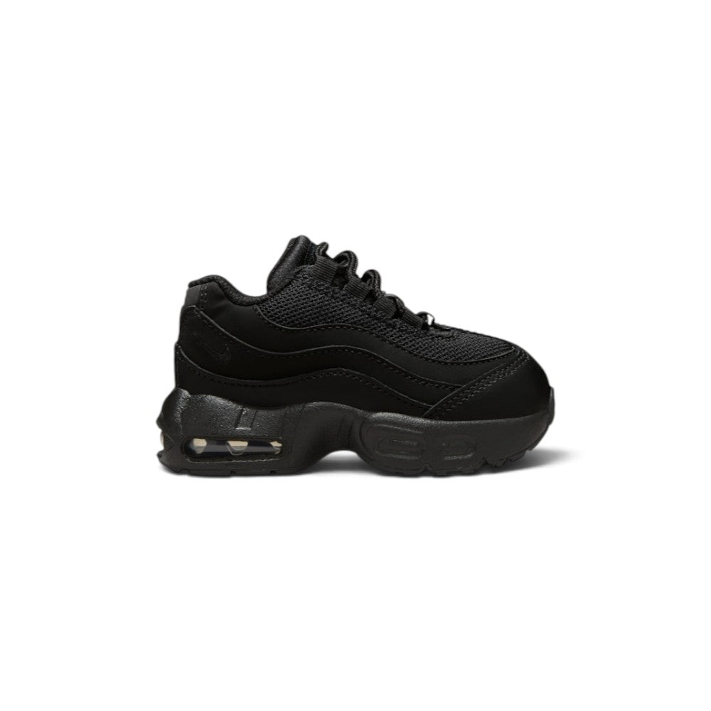 Highlights the lateral profile showing the layered wavy black leather muscle panels, breathable mesh upper, mini tonal embroidered heel Swoosh, sculpted black foam midsole, and visible Max Air heel chamber.