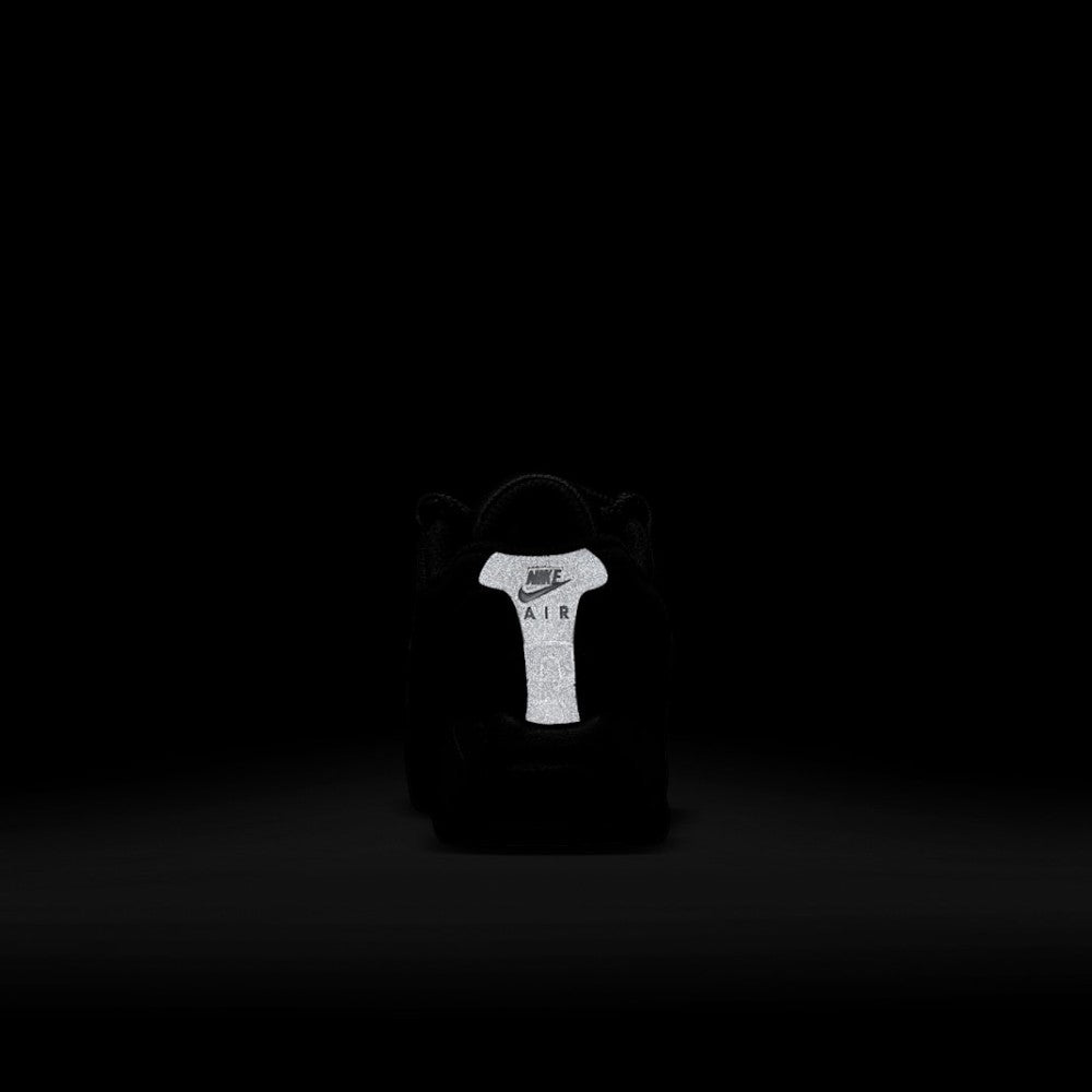Demonstrates safety visibility in dark conditions, highlighting the high-intensity glowing 3M reflective rear heel spine panel stamped with the Nike Air emblem.