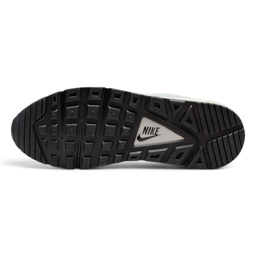 Displays the full-length black rubber Waffle outsole, featuring high-traction square tread pods surrounding a central white triangular shank stamped with a black "NIKE" text logo.