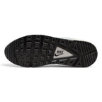 Displays the full-length black rubber Waffle outsole, featuring high-traction square tread pods surrounding a central white triangular shank stamped with a black "NIKE" text logo.