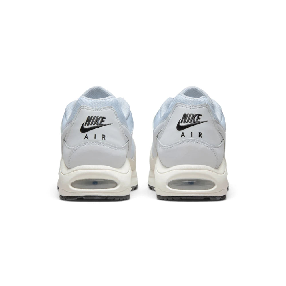 Focuses on the rear profile, highlighting the grey leather heel panels printed with black "NIKE AIR" logos and the wide stack of the cream foam midsole base enclosing the Air unit.