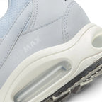 Highlights the "unreal" clean finish where the sculpted cream foam midsole meets the black Waffle rubber sole, showing the tonal debossed "AIR MAX" lettering above the clear Max Air window.