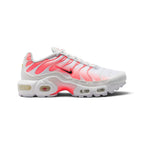 Highlights the lateral silhouette displaying the crisp white mesh upper, striking Hot Lava gradient TPU cage overlay, mini black Nike Swoosh with pink trim, glossy white toe bumper, sculpted white midsole, visible Max Air heel and forefoot windows, and bright lava whale's tail arch plate.
