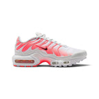 A Nike Air Max Plus sneaker in white and vibrant pink, featuring a white mesh upper, pink synthetic overlays, a black Nike Swoosh, and a white midsole with visible air cushioning units.