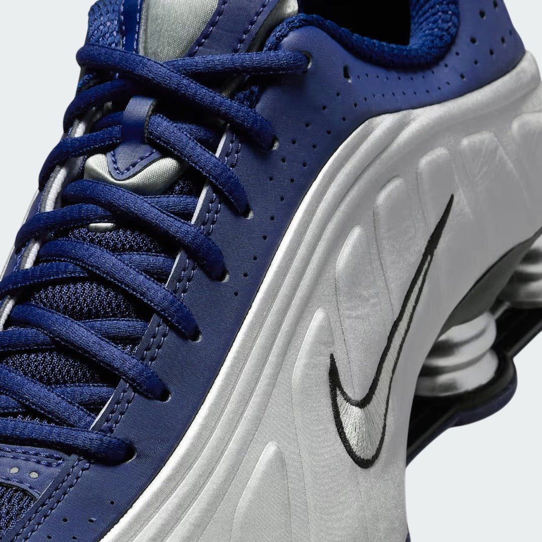 Close-up zoom on the front of the Nike Shox R4 women's trainers, showing the synthetic overlays and lacing system.