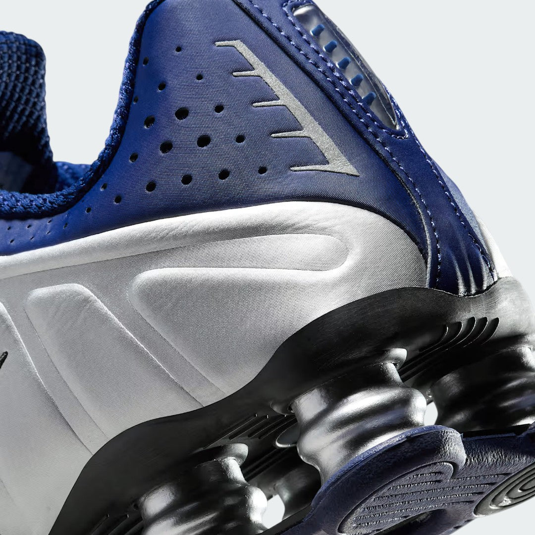 Detailed zoom on the sole of the Nike Shox R4 women's trainers, highlighting the visible Shox cushioning pillars and the durable rubber outsole.