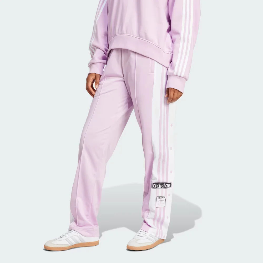 The Light Orchid Adibreak pants, highlighting the full-length white snap buttons and the contrast 3-Stripes against the soft purple base.