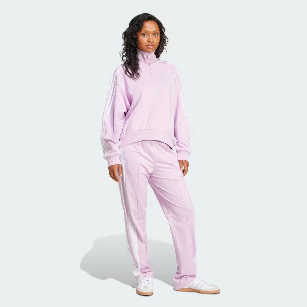 Woman wearing a pink tracksuit on a white background
