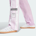 A close-up showing the bottom snap buttons opened to reveal a glimpse of the footwear underneath.