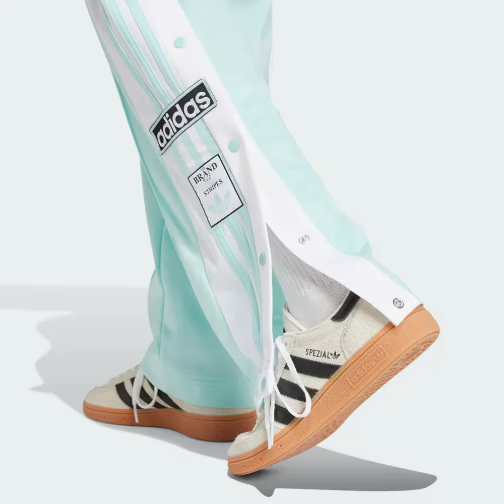 A close-up showing the bottom snap buttons opened to reveal a glimpse of the footwear underneath.