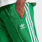 Emphasising the sharp visual contrast of the premium embroidered white Trefoil logo standing proud against the rich green fabric backdrop.
