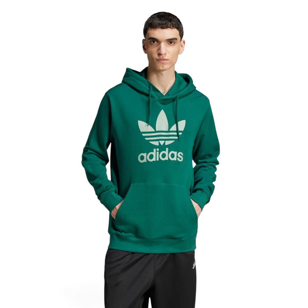 Model profile of the Collegiate Green Adidas hoodie, showcasing the relaxed regular fit and the structured ribbed cuffs. Main image