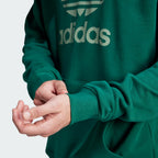 Close-up of the Trefoil logo on the chest, highlighting the crisp screen-print quality against the green fabric.