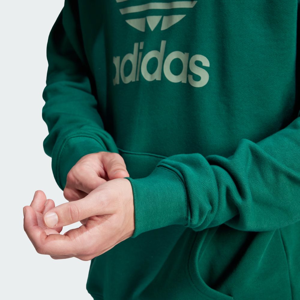 Close-up of the Trefoil logo on the chest, highlighting the crisp screen-print quality against the green fabric.