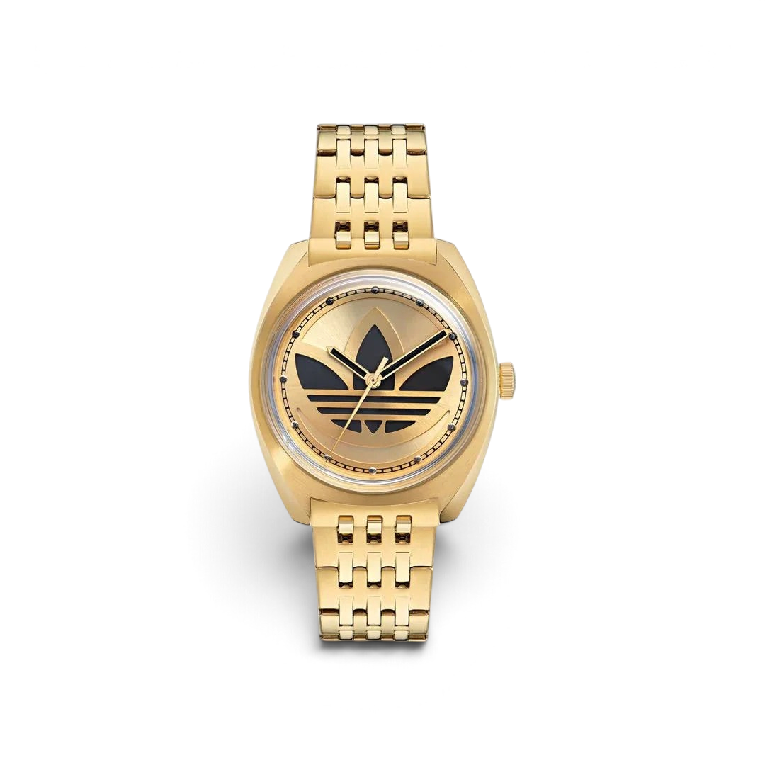 Adidas Edition One Watch in gold metallic, front view showing the watch face with a large, cut-through Trefoil logo and a domed lens.