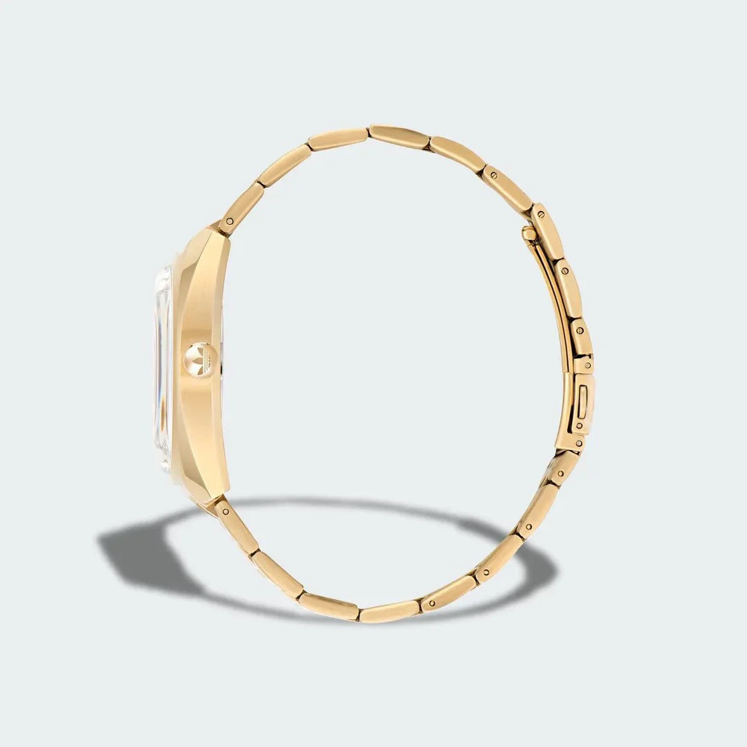 Adidas Edition One Watch in gold metallic, side profile showing the thickness of the case and the links of the stainless steel bracelet.