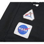 Details the high-definition Artemis mission patch and the precision of the silver print.