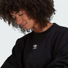 Close-up zoom on the fabric of the Adidas Adicolor Essentials Fleece Crew Sweatshirt in black, showing the soft fleece texture and the small Adidas Trefoil logo.