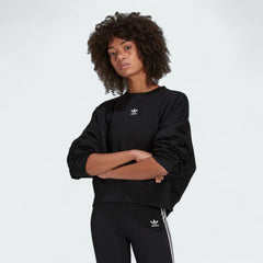 Adidas Adicolor Essentials Fleece Crew Sweatshirt Women's in black, front view showing the ribbed crewneck, cuffs, and hem, and a small Adidas Trefoil logo on the chest.