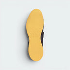 Displays the specialised flat-profile geometric traction pattern of the low-profile rubber sole, engineered for unreal floor contact and a zero-slip mat plant.