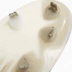 Close-up of a beige athletic shoe sole showing the textured tread pattern and small metallic outsole studs.