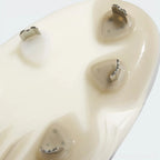 Close-up of a beige athletic shoe sole showing the textured tread pattern and small metallic outsole studs.