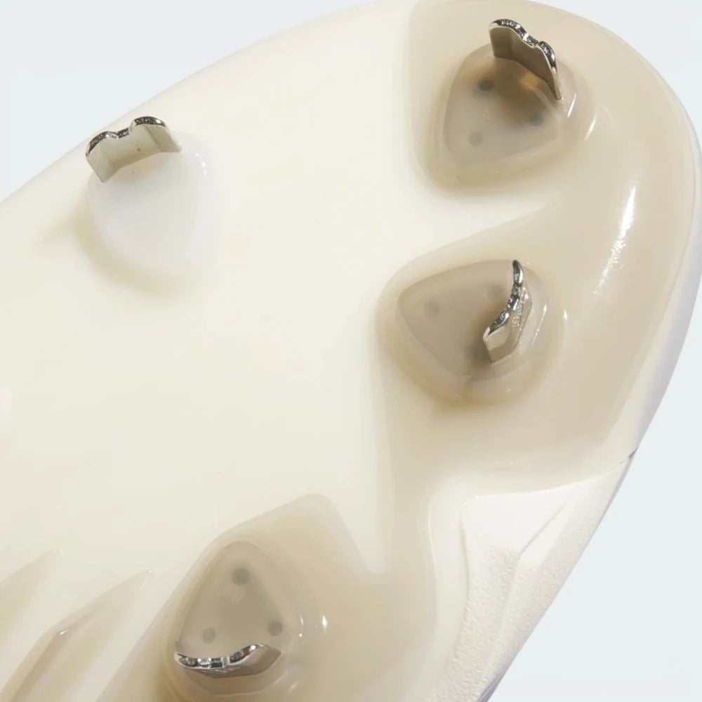 Close-up of a beige athletic shoe sole showing the textured tread pattern and small metallic outsole studs.