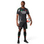 Full-length studio shot of a male model wearing the complete away kit, including the black authentic jersey, matching shorts with red accents, and black socks featuring team branding.