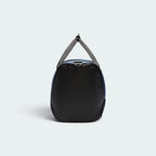 Displays the sleek black coated side profile of the duffel bag, showing the rounded structural frame, top webbing handles joined together, and the side compartment zip track.