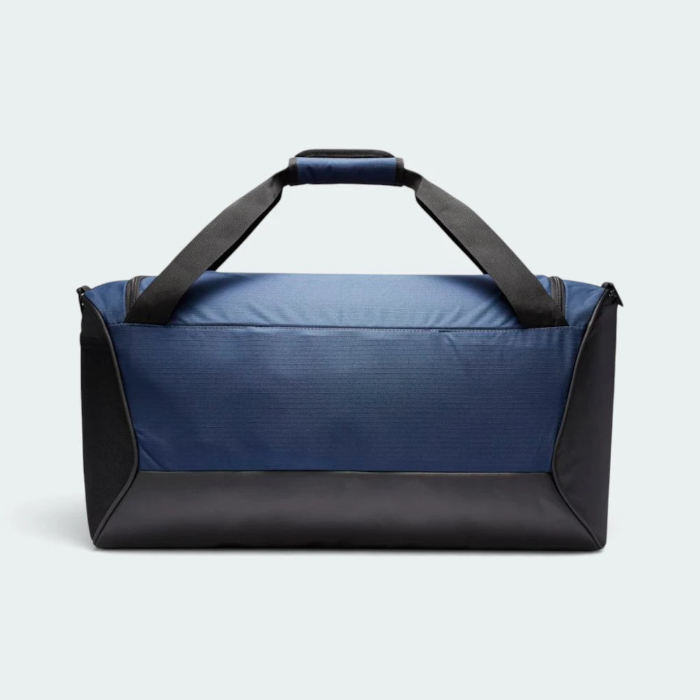 Shows the clean Midnight Navy back panel with heavy-duty black corner reinforcement, the black coated bottom base, and the top grab handles held together by a navy padded grip wrap.