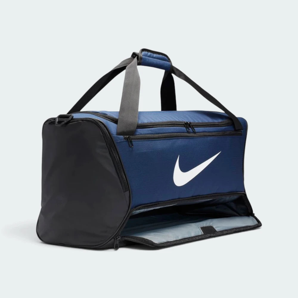Details the zip-around bottom compartment fully unzipped and laid open, revealing the spacious grey-lined lower section designed to isolate shoes or wet kit from clean gear.