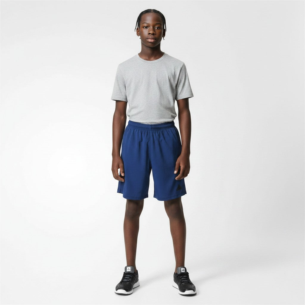 Person wearing a gray t-shirt and blue shorts on a white background