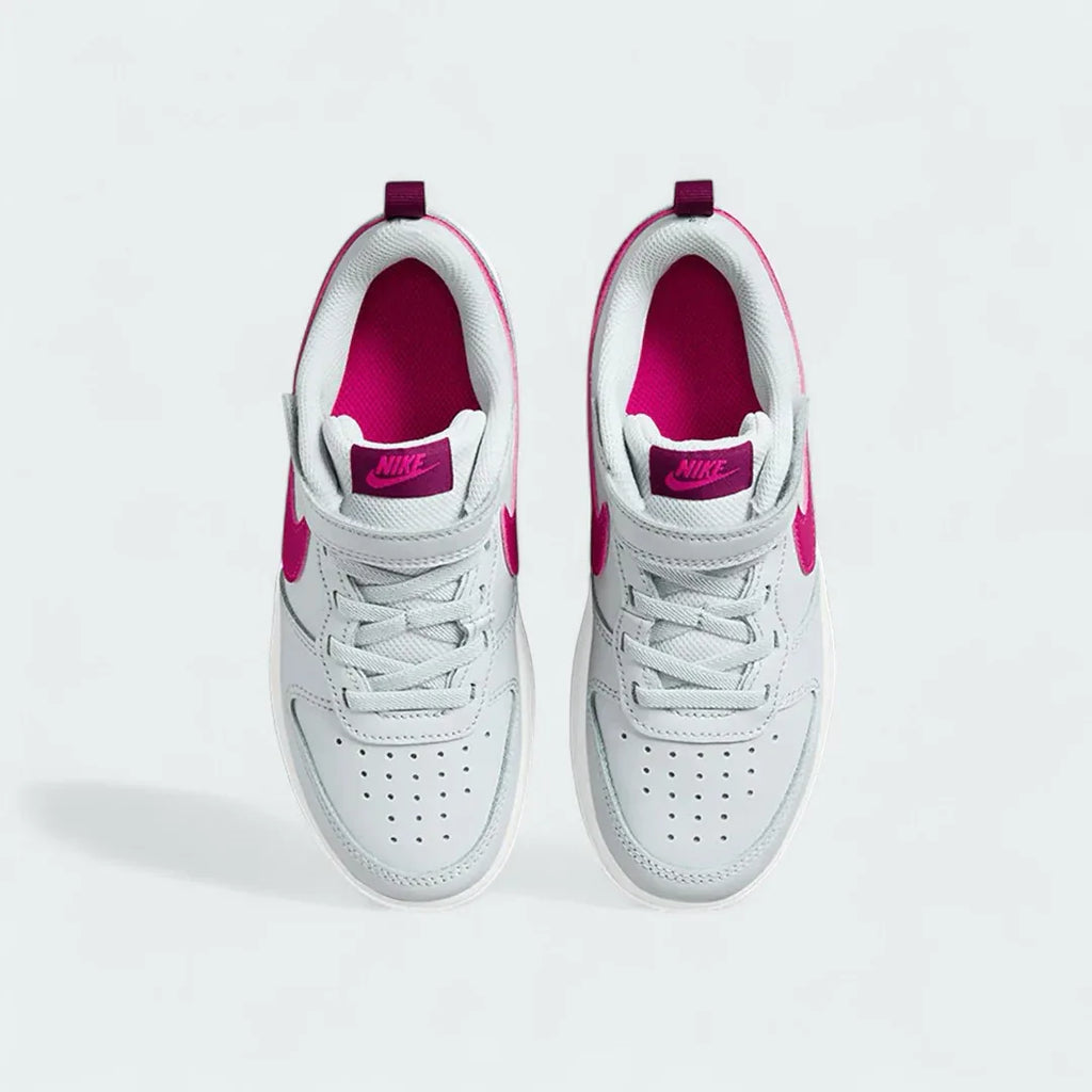 Top-down view of a pair of Nike Court Borough Low 2 Girls' trainers in off-white and pink, highlighting the lace-up closure and perforated toe box.