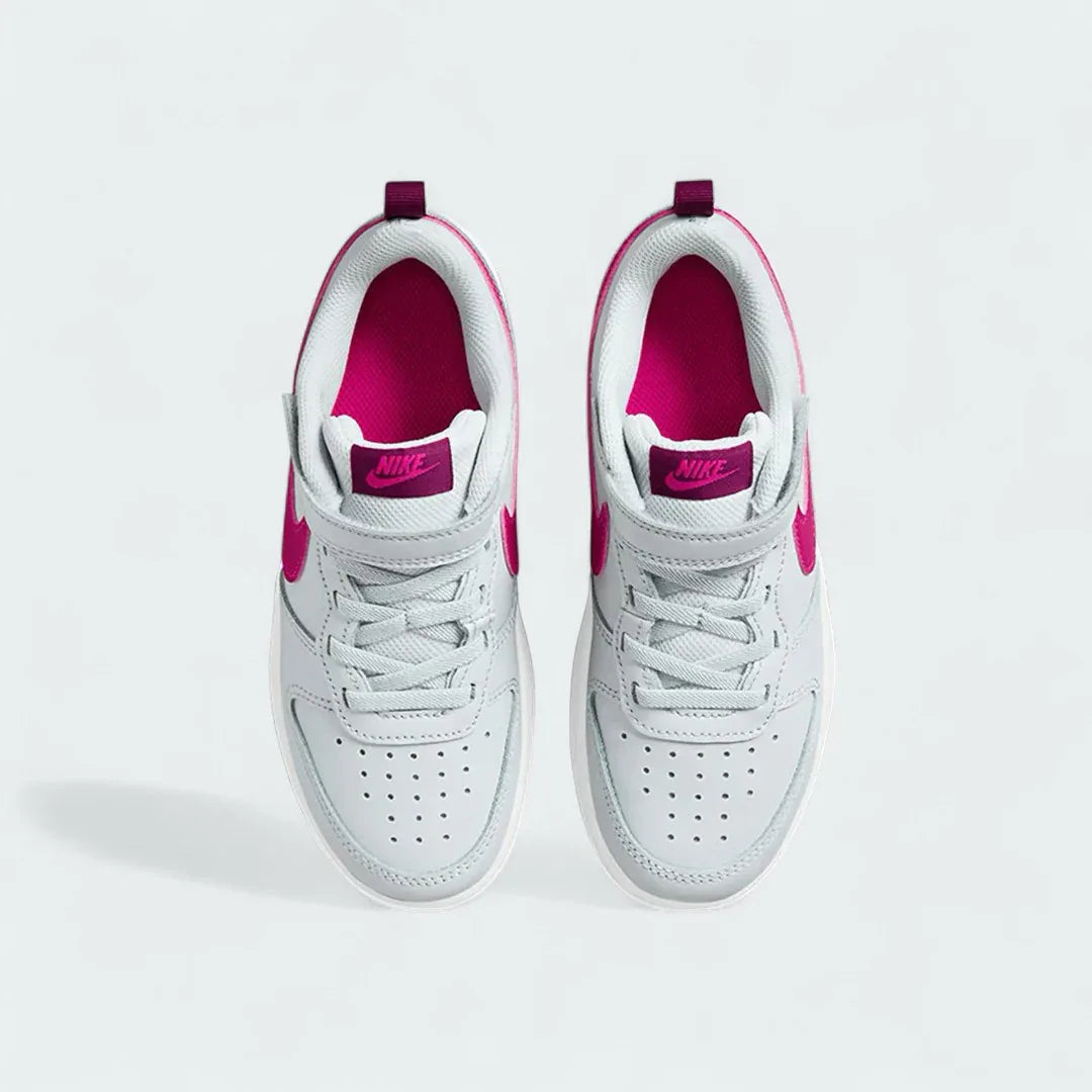 Top-down view of a pair of Nike Court Borough Low 2 Girls' trainers in off-white and pink, highlighting the lace-up closure and perforated toe box.