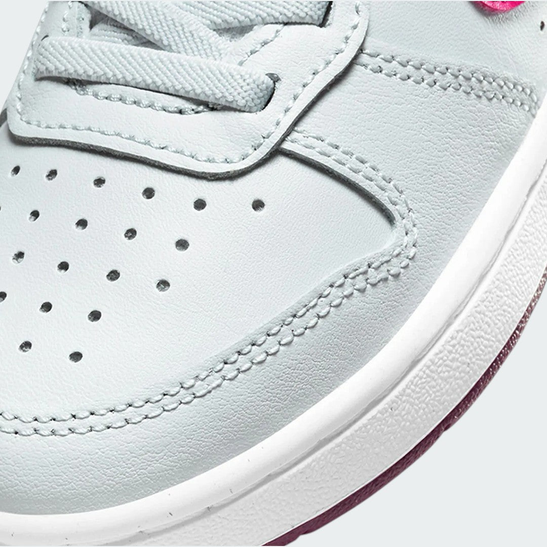Close-up zoom on the front of the Nike Court Borough Low 2 Girls' trainers, showing the perforated toe box, lacing system, and texture of the upper materials.
