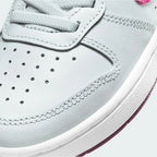 Close-up zoom on the front of the Nike Court Borough Low 2 Girls' trainers, showing the perforated toe box, lacing system, and texture of the upper materials.