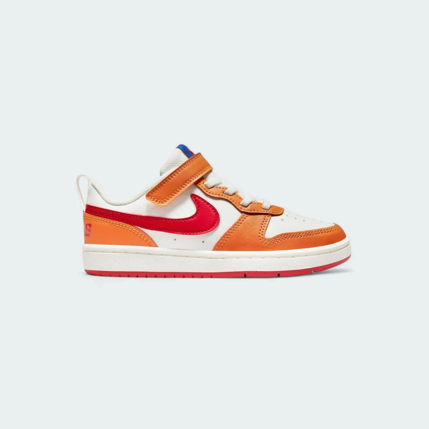 Nike Court Borough Low 2 children's trainers in sail (off-white) with red, orange, and blue accents, side profile showing classic design and Nike Swoosh. Main image