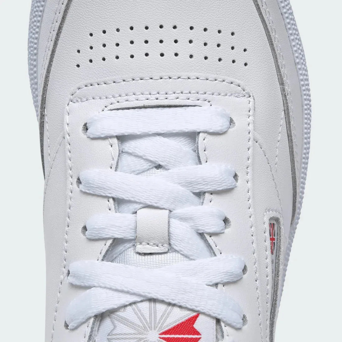 Close-up of Reebok Club C 85 Women's White Leather Trainers BS7686 smooth leather texture, stitching detail, and tongue label