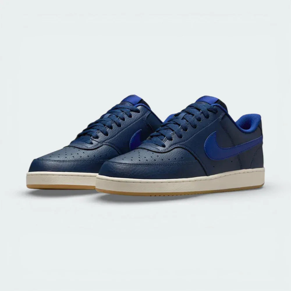 Angled shot of both Nike Court Vision trainers side by side, showcasing the retro 80s silhouette and the rich navy colourway.