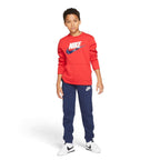 Full-body action pose of the young model wearing the complete red-and-navy outfit, illustrating proportions and daily wear styling.