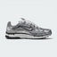 Highlights the high-velocity sweep of the black-outlined metallic silver Nike Swoosh, showing the breathable metallic grey mesh base, complex grid of chrome vertical and horizontal overlays, and white foam midsole.