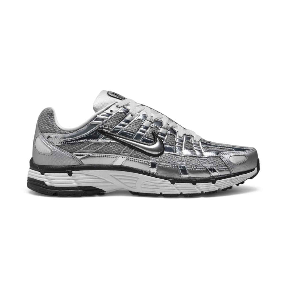 Highlights the high-velocity sweep of the black-outlined metallic silver Nike Swoosh, showing the breathable metallic grey mesh base, complex grid of chrome vertical and horizontal overlays, and white foam midsole. Main image