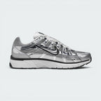 Highlights the inner profile showing the matching chrome overlay cage pattern, black Swoosh, white foam midsole wall, and structured grey mesh heel collar.